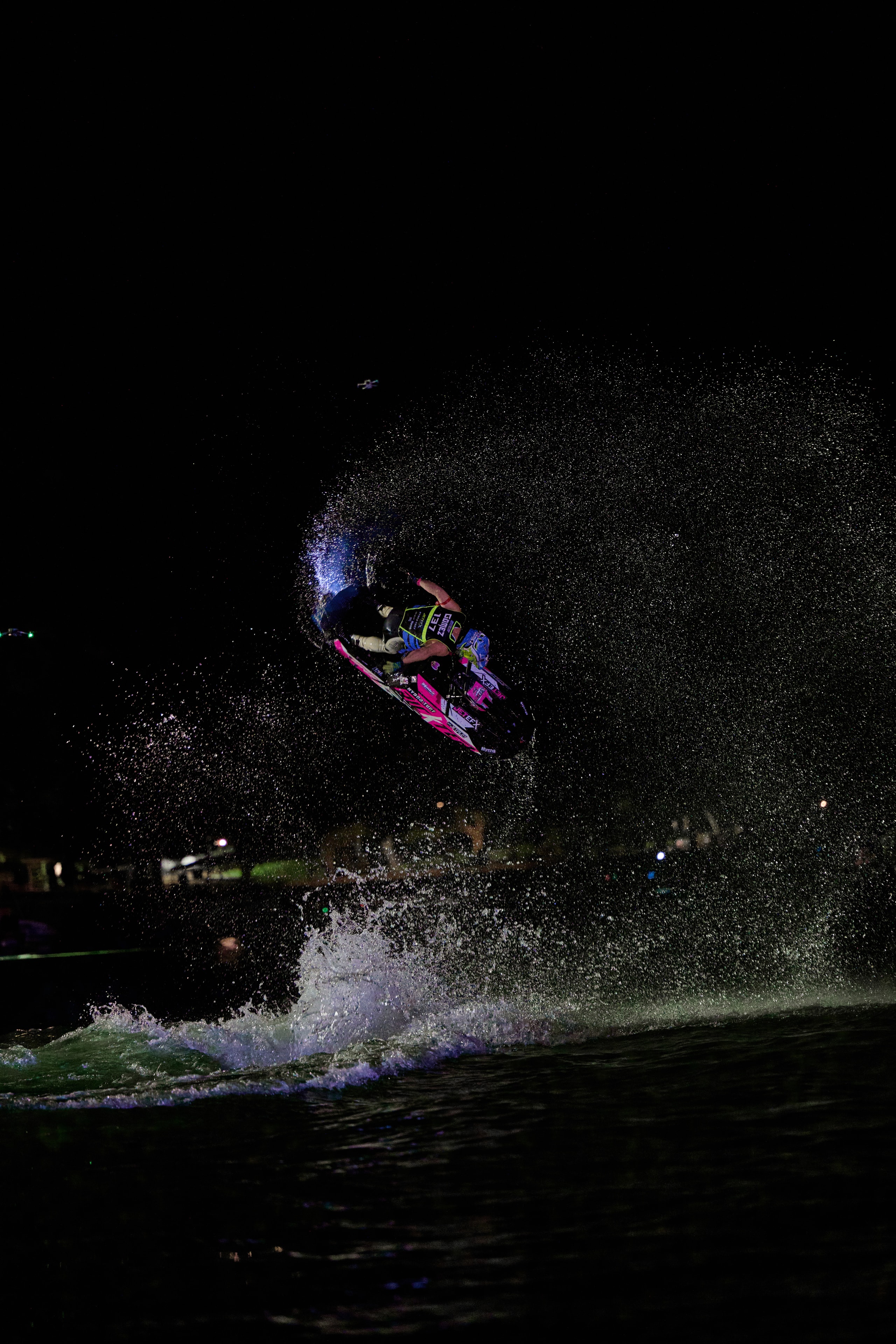 Action sports — jetski performer airborne at night with dramatic lighting