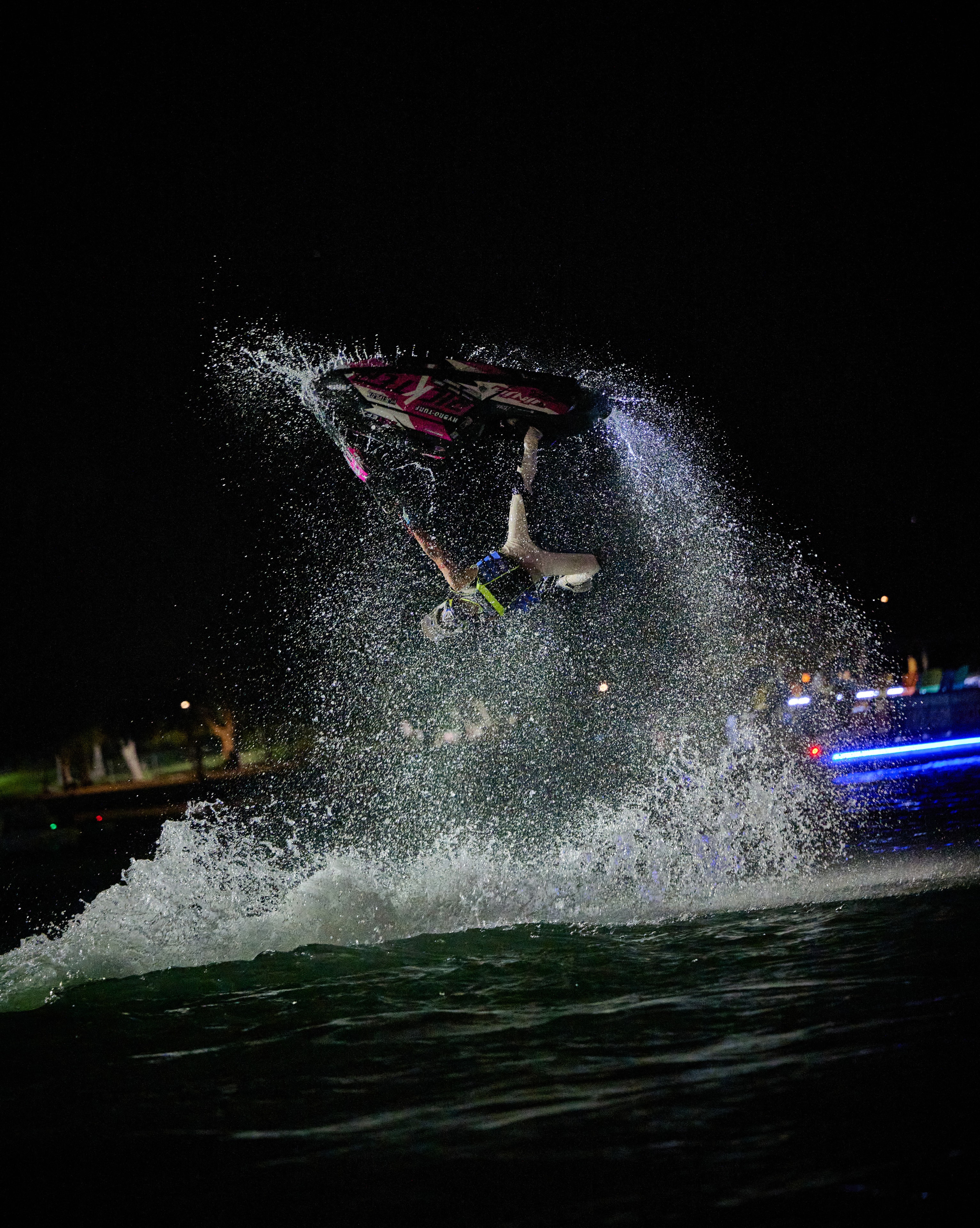 Action sports — jetski rider inverted with water spray and event lighting