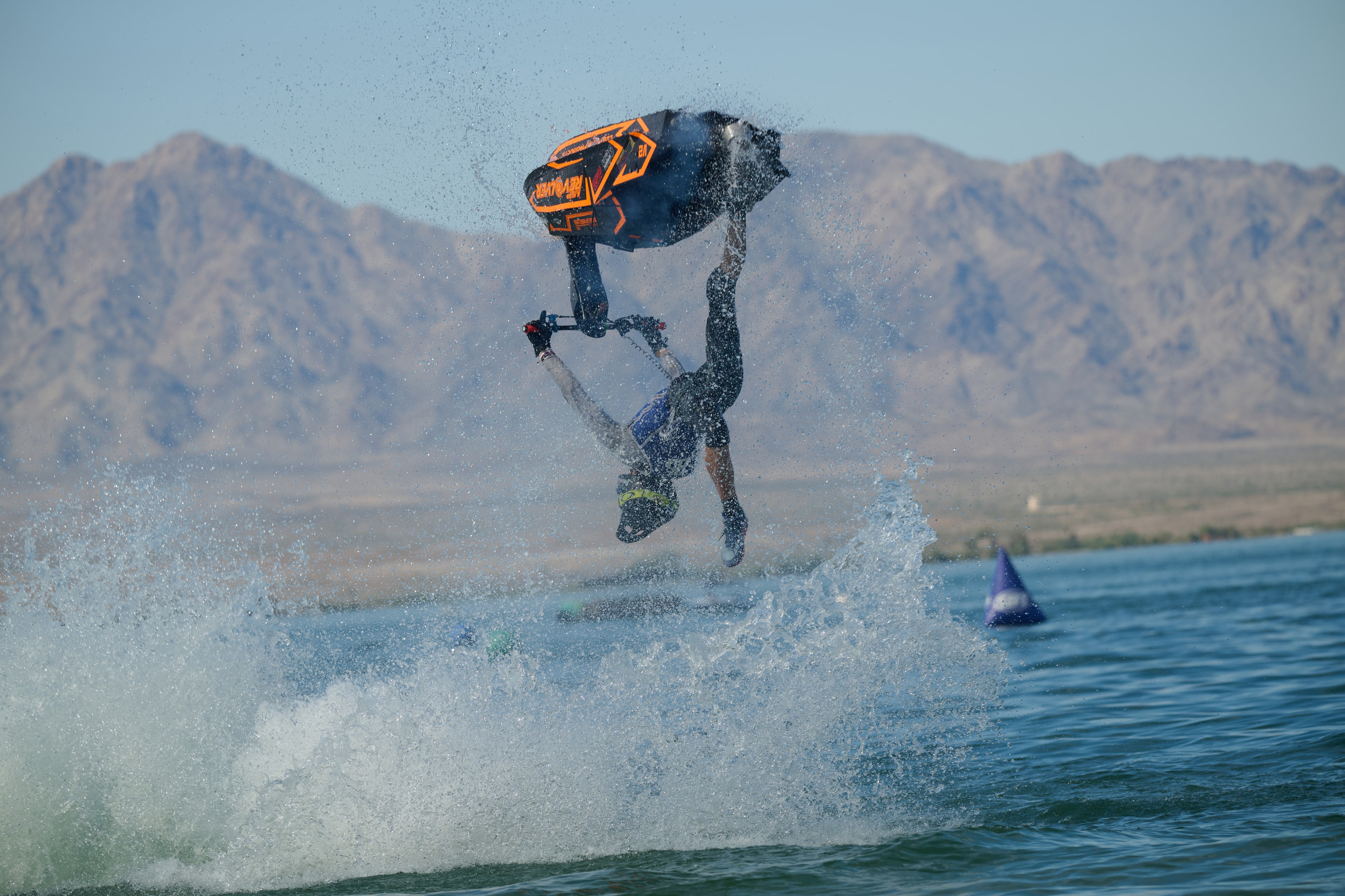Action sports — jetski rider inverted with Revolver seat, mountain backdrop